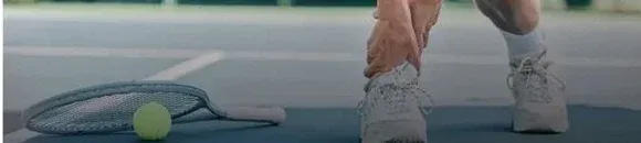 Athlete tending to a sport-related injury on a tennis court