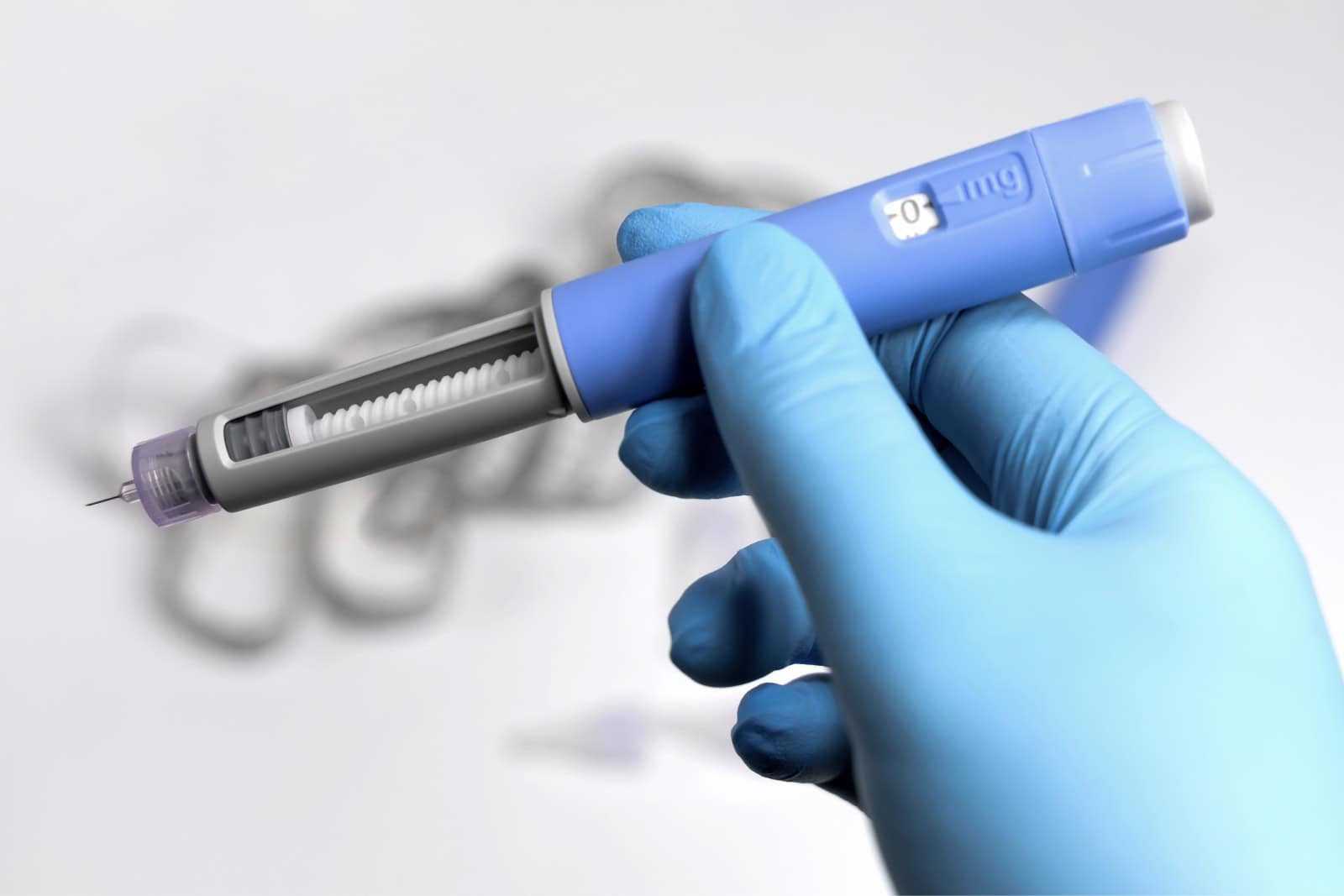 Primer plano de una mano con guante que sostiene una pluma de inyección de semaglutida, con el dispositivo que se utiliza para administrar este eficaz medicamento para la pérdida de peso.