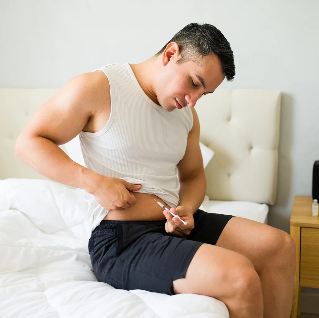 Hombre aplicándose en casa una inyección de terapia con péptidos — Ideal Medical, Aventura